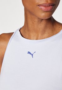 Heledad helesinine särk ümmarguse kaelusega, valmistatud pehmest kangast, millel on rindkerel väike lilla Puma logo.