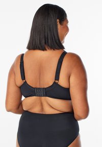 Black bikini top with adjustable straps, featuring a hook-and-eye closure at the back, made of smooth, stretchable fabric.