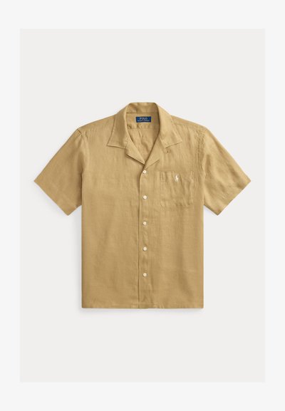 Camisa beige de manga corta con botones, cuello campamento y bolsillo en el pecho con el logo Polo Ralph Lauren bordado en blanco.