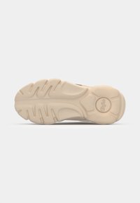 Sneaker outsole in beige rubber, featuring thick treads for traction and a smooth arching design. Notable round logo on the heel.