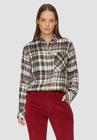 Lange mouw geruite shirt in groen, wit en burgundy met een button-down kraag en een borstzak, gecombineerd met rode corduroy broek.
