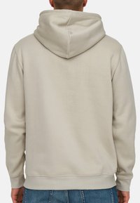 Hættetrøje i lys beige, fremstillet af blødt stof. Har en kengurulomme og ribkantede ærmer og kant forneden, med en afslappet pasform.