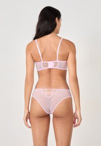 Rosa durchsichtiger Lingerie-Satz mit Punktenmuster, verstellbaren Trägern und floraler Stickerei auf der Rückseite, mit einer Schleifendetail am Verschluss.