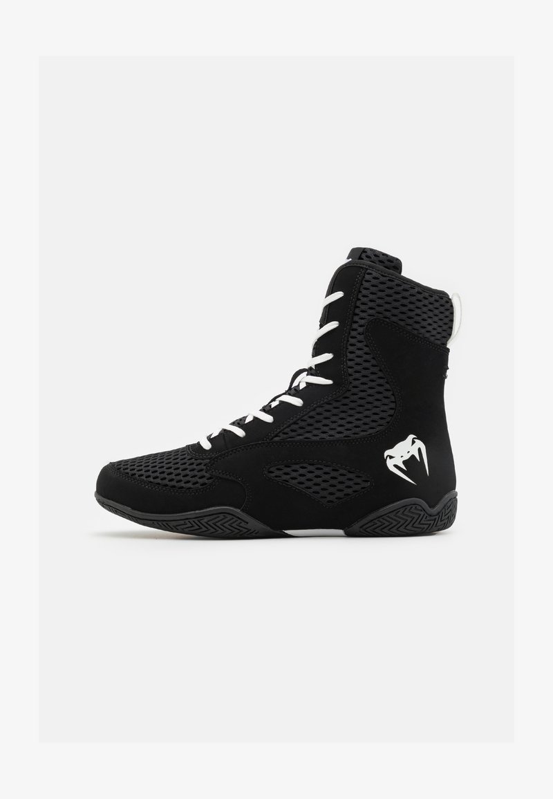 Sapatos pretos de cano alto com painéis em malha, atacadores brancos e um logótipo proeminente. A sola preta texturizada apresenta um padrão em ziguezague para maior tração.