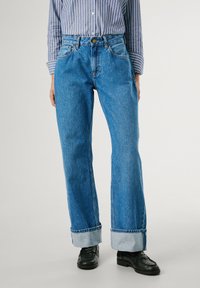 Blue denim pants with a high waist, straight leg, and rolled cuffs. Features classic five-pocket design and metal button closure.