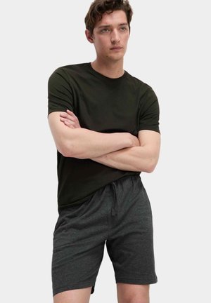 T-shirt à manches courtes vert foncé associé à un short à cordon de serrage gris anthracite, tous deux fabriqués dans un tissu doux et respirant avec une coupe décontractée.