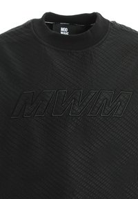 Sudadera negra con un patrón texturizado y acolchado, y un logo "MWM" en relieve en el centro. Presenta un cuello redondo y puños de canalé.