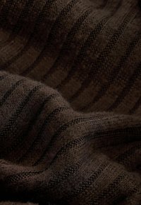 Tejido de punto marrón oscuro con rayas horizontales, que presenta una superficie suave y texturizada, con fibras visibles, creando una apariencia acogedora.