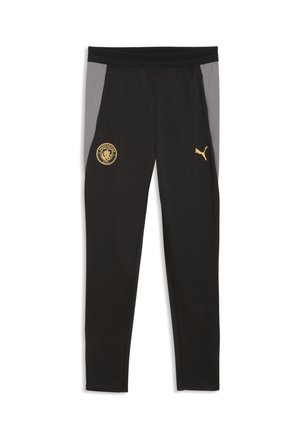 Czarne spodnie sportowe z szarymi panelami bocznymi, z złotym logo Manchester City po lewej stronie i złotym logo Puma na prawej udzie.