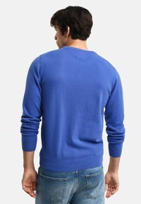 Maglione a girocollo e maniche lunghe in misto lana blu brillante. Presenta polsini e orlo a costine; texture liscia con una silhouette aderente.