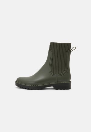 Bota de lluvia hasta el tobillo en verde oliva con panel lateral elástico acanalado, lengüeta en el talón, tacón bajo en bloque y suela con dibujo rugoso.