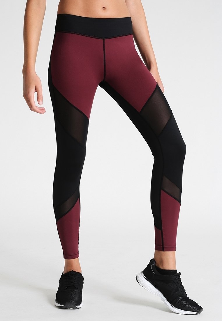 Leggings con un design bordeaux e nero con inserti in rete. Realizzati in un materiale elastico con una vita alta per il massimo comfort.