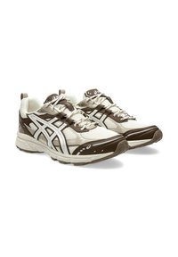 Men's athletic shoes with a cream mesh upper and brown synthetic overlays. Features white accents, patterned soles, and traditional lacing.