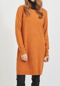 Orange gestricktes Kleid mit langen Ärmeln, gerippten Bündchen und Saum. Weicher Stoff, mittellanger Schnitt und runder Ausschnitt.