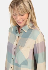 Multicolored button-up shirt in lightweight fabric, featuring a geometric pattern with soft colors and a chest pocket.