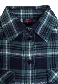 Koszula w kratę z flaneli w kolorach zielonym, granatowym i białym, z kołnierzykiem zapinanym na guziki oraz dwoma przednimi kieszeniami. Materiał jest miękki i ma ziarnistą fakturę.