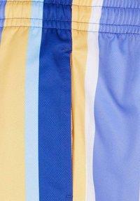 Svømmebukser med vertikale striper i gul, lys blå, blå og hvit. Laget av lett materiale med elastisk linning.