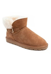 Botín de ante marrón con puño de borreguito, presenta una correa y detalle de hebilla, suela de goma plana y diseño de punta redonda.