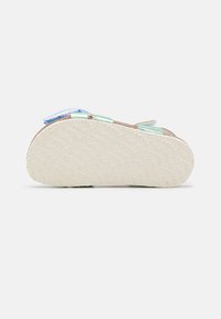 Sandal sål med en texturerad beige gummibotten med präglade mönster, stödjande brun fotbädd och flerfärgade remaccents.