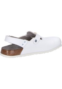 White slip-on shoe with a textured leather upper, adjustable strap, and natural-colored sole. Rounded toe and open back design.