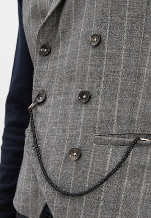 Grau gestreifter, doppelt geknöpfter Weste mit vier braunen Knöpfen und einer schwarzen, mit Perlen besetzten Taschenuhrenkette, die an der Seite befestigt ist.