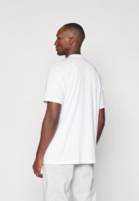 adidas Performance WORLDWIDE HOOPS LOGO GRAPHIC - Trükipildiga T-särk - white