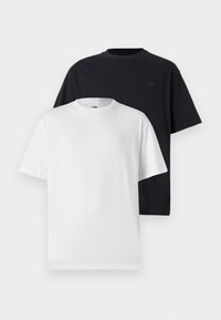 Duas t-shirts de manga curta: uma preta e uma branca. Ambas têm um decote redondo e um logótipo subtil no peito, feitas de um tecido de algodão macio.
