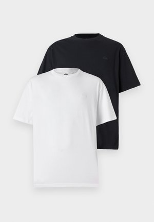 Zwei Kurzarm-T-Shirts: eines in Schwarz und eines in Weiß. Beide haben einen runden Halsausschnitt und ein dezentes Logo auf der Brust, gefertigt aus weichem Baumwollstoff.