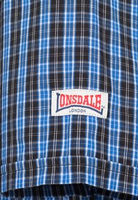 Men's plaid shirt in blue, black, and white; cotton fabric with a woven texture. Features an ONSDALE logo label at the hem.