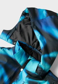 Veste imperméable à capuche avec un design dégradé bleu et noir. Elle dispose d'une fermeture éclair à l'avant et d'une texture de tissu lisse et brillante.