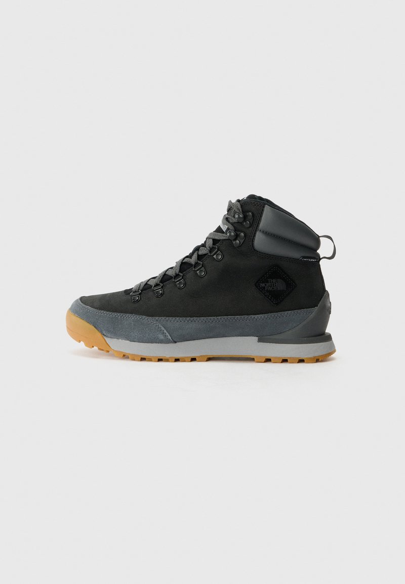 Botas de caminhada de cano alto pretas, feitas de camurça texturizada e materiais sintéticos, com detalhes cinzas, sola de borracha robusta e atacadores cinzas.