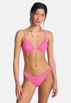 Różowy prążkowany komplet bikini z trójkątnym biustonoszem na regulowanych ramiączkach oraz dopasowanym niskim paskiem. Gładka faktura, bez wzorów.