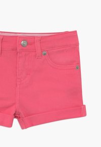 Růžové džíny šortky s klasickým designem, pěti kapsami, ohrnutým lemem a kovovým zapínáním na přední straně.
