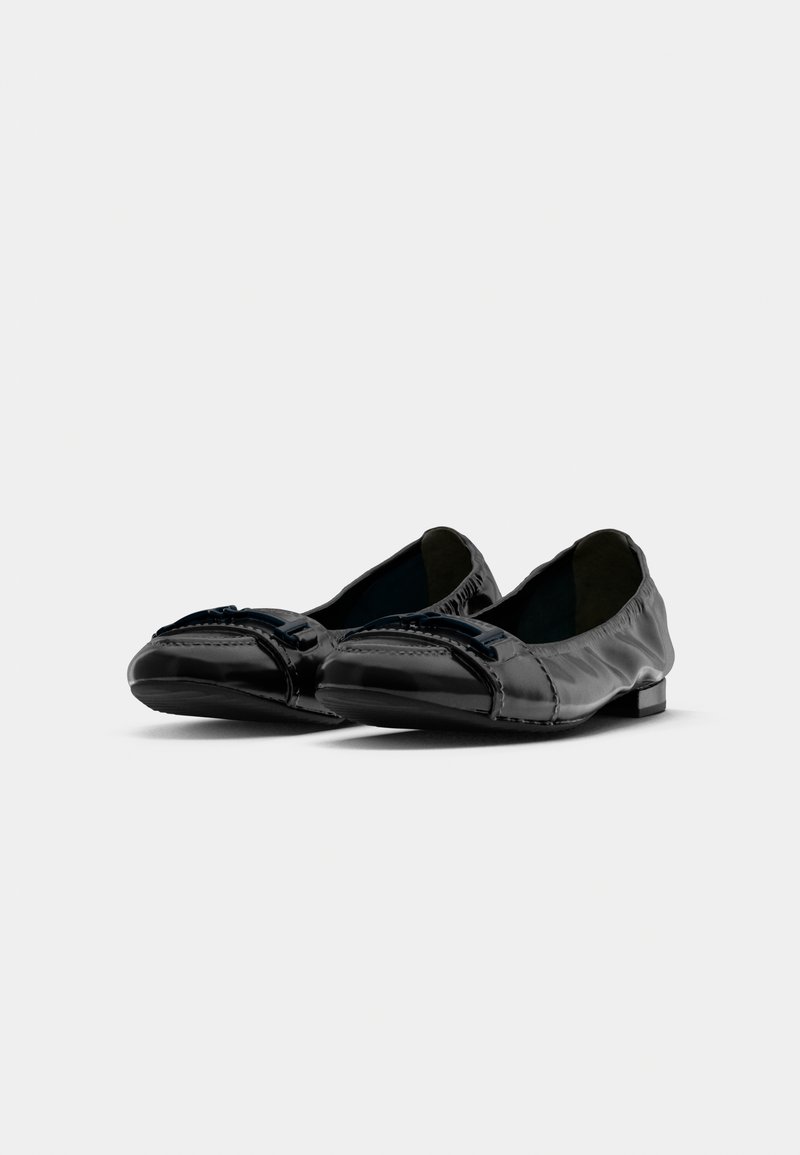 Une paire de ballerines en cuir noir avec des orteils ronds et des boucles décoratives, présentées sur fond blanc.