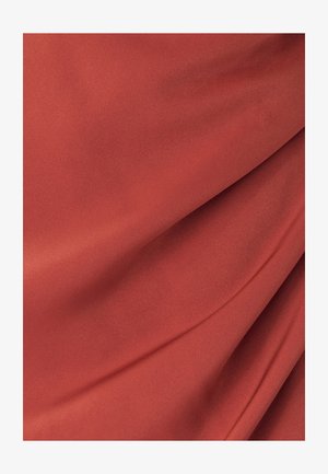 Red fabric with a smooth texture, featuring soft drapes and folds, showcases a uniform appearance without any visible patterns or seams.