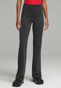 Korkeavyötäröiset, levenevät mustat housut ribbikankaasta, jossa on sileä pinta ja tiukka istuvuus lantiolla, leveällä lahkeella.