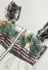 Robe sans manches avec imprimé palmiers verts et rayures violettes, présentant des bretelles à volants et un détail de boutons sur le buste, en tissu texturé.