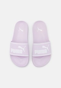 Lila csúszásmentes szandál, texturált pánttal, fehér Puma logóval. Puhább anyag és kontúrozott talpbetét a kényelemért.