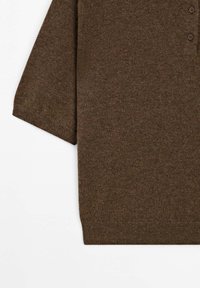 Brun kortærmet strik polo t-shirt med ribbede manchetter og kant, der har en delvis knaplukning på en hvid baggrund.