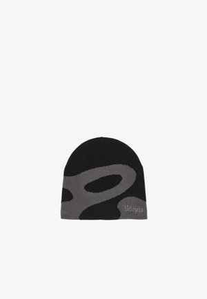 Gorro de punto negro y gris con un estampado abstracto gris y letras bordadas cerca del borde inferior, sobre un fondo blanco.