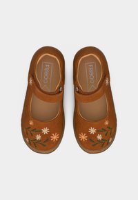 Καφέ παπούτσια τύπου Mary Jane με κεντημένα ροζ και λευκά λουλούδια και πράσινα φύλλα, με ρυθμιζόμενους ιμάντες και μαλακές ενσωματωμένες σόλες.