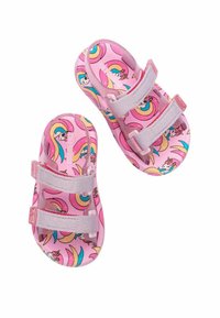 Sandales en plastique roses ornées d'un motif delicieux de licornes, avec trois sangles réglables grises en Velcro et une forme arrondie.