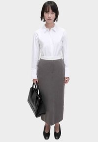 White button-up shirt, gray pencil skirt, black handbag, and black shoes. Simple design, smooth textures, and neutral colors. Professional look.