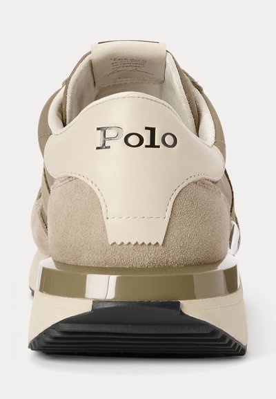 Beige och tan sneaker i mocka och läder, svart "Polo" logotyp på hälen och dämpad sula med svart slitbana synlig bakifrån.