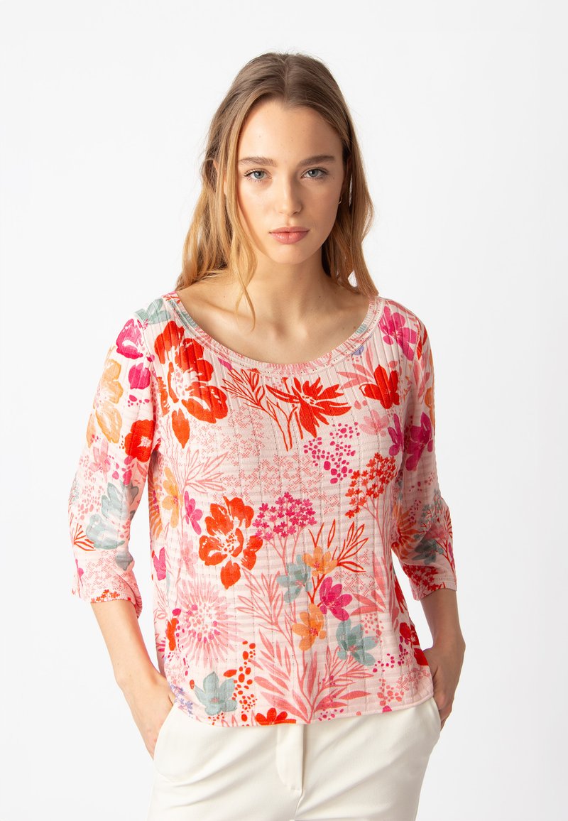 Top leggero con motivo floreale in rosa, con fiori arancioni, rossi e blu teal. Maniche a tre quarti e scollatura ampia.