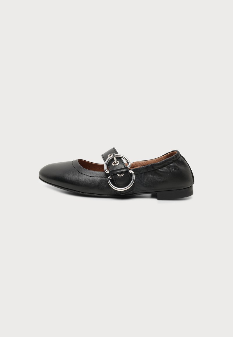 Chaussure plate en cuir noir avec un bout arrondi et une large bride avec boucle double anneau argentée sur le dessus.