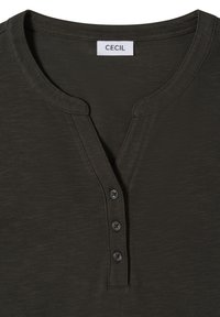 Dunkelgrünes Kurzarmshirt mit V-Ausschnitt, einer geknöpften Blende und weichem, strukturiertem Stoff. Das Etikett trägt die Aufschrift "CECIL".