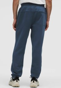 Donkerblauwe sweatpants met een relaxte pasvorm, elastische tailleband, ophaalbanden en een achterzak. Gemaakt van zachte, textuurstof.