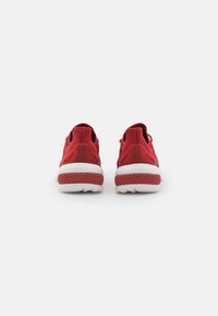 Scarpe sportive rosse con tomaia in maglia traspirante e suola bianca a contrasto. Accenti in gomma testurizzata al tallone e sulla suola.