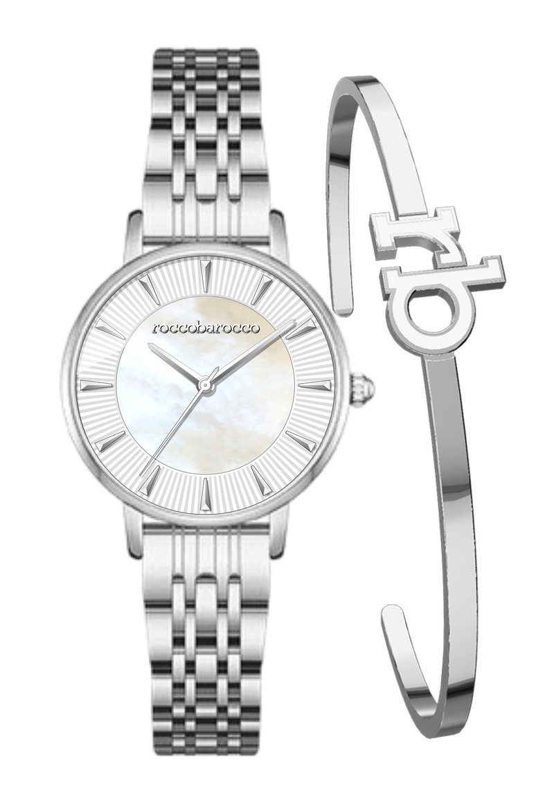 Sölvfärgad rostfri stålklocka med urtavla i pärlemor, romerska siffror och flätad rem. Kommer med ett silverarmband med en logotyp.